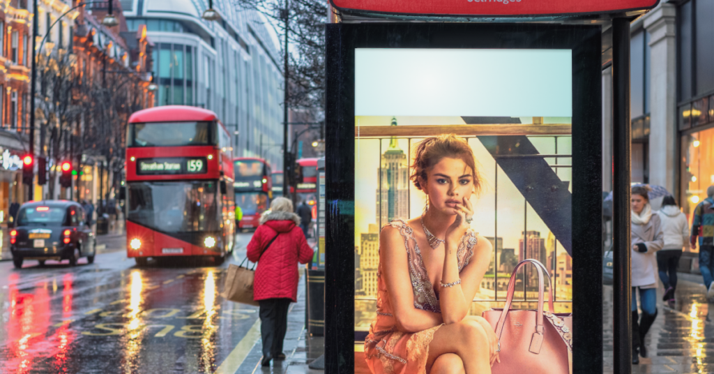 Outdoor digital signage screen on a bus stop showing an advertising