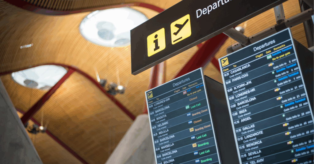 A digital signage screen at the airport showing departures