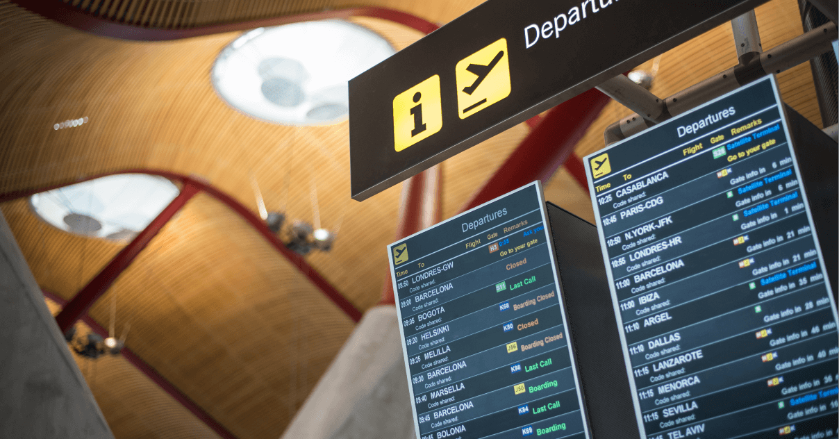 A digital signage screen at the airport showing departures